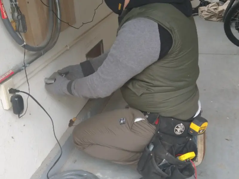 Electrician performing outlet wiring in a Algonac garage